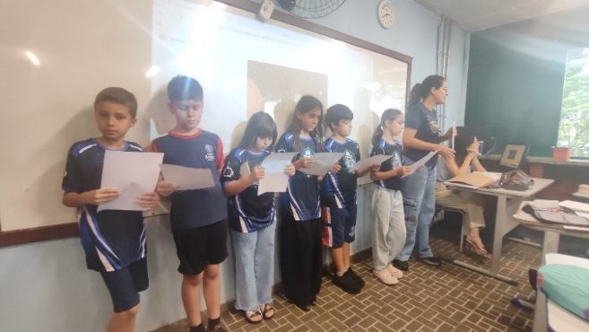 Integrantes lendo durante a visita à escola
